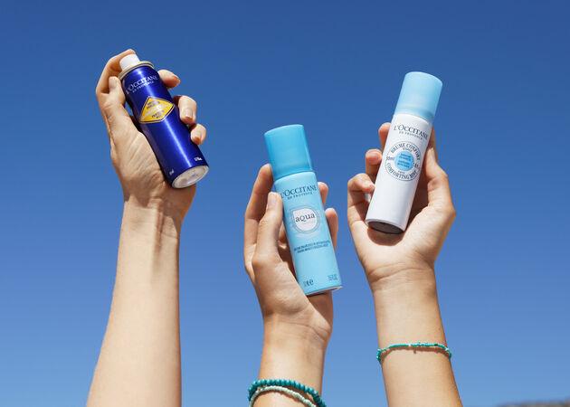 three hands holding up face mists in the sky